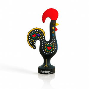 A black rooster figurine adorned with red and yellow feathers, representing the Galo de Barcelos souvenir from Portugal.