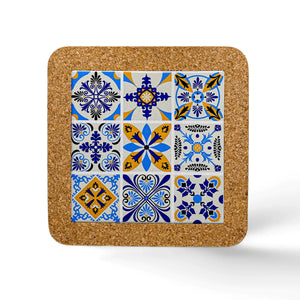 Square tile coaster with intricately patterned designs in blue, yellow, and white. The patterns vary, including floral and geometric motifs arranged in a 3x3 grid. This charming souvenir from Portugal boasts a durable cork base and rests on a white surface.