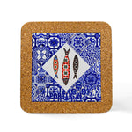 A square cork coaster with a vibrant design, perfect as a souvenir from Portugal. The coaster features a central diamond-shaped section with three decorated fish and the word "Portugal" beneath them. Surrounding the diamond is a blue patterned background resembling traditional Portuguese tiles.