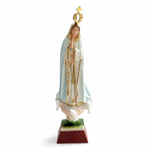 Front view of an Our Lady of Fátima religious statue souvenir featuring gold accents, white mantle, crown, and prayerful pose.