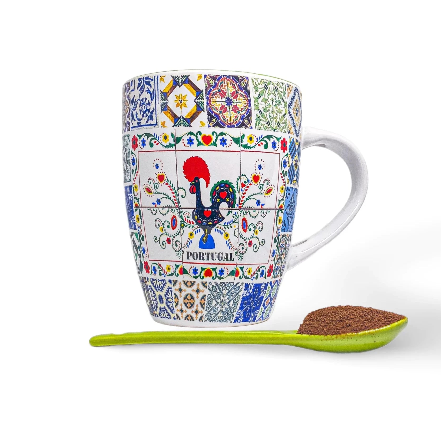 A colorful coffee mug decorated with traditional Portuguese tile patterns, featuring the iconic Barcelos Rooster in the center and the word "PORTUGAL" beneath it. A bright green spoon filled with ground coffee is placed in front of this charming Green Portuguese coffee mug. White background.