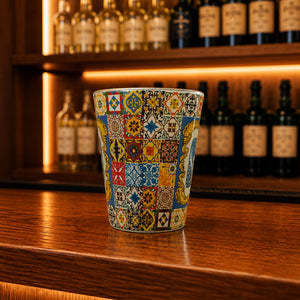 Guimarães souvenir shot glass decorated with colorful Portuguese azulejo tile patterns displayed on a wooden bar counter