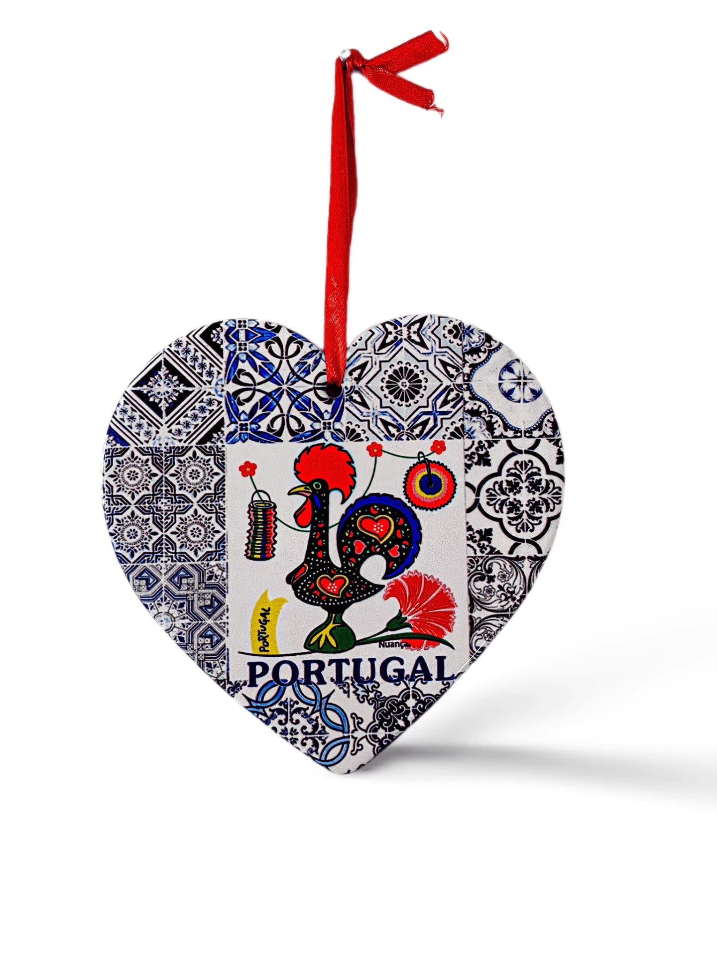 A heart-shaped ornament features a colorful rooster design with the word "Portugal" written below it. The rooster is surrounded by intricate blue and white tile patterns. A red ribbon is attached to the top for hanging, and a cork base adds a charming touch to this delightful souvenir.