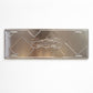 Back side of Lisboa metal souvenir sign showing raw metal surface and mounting slots