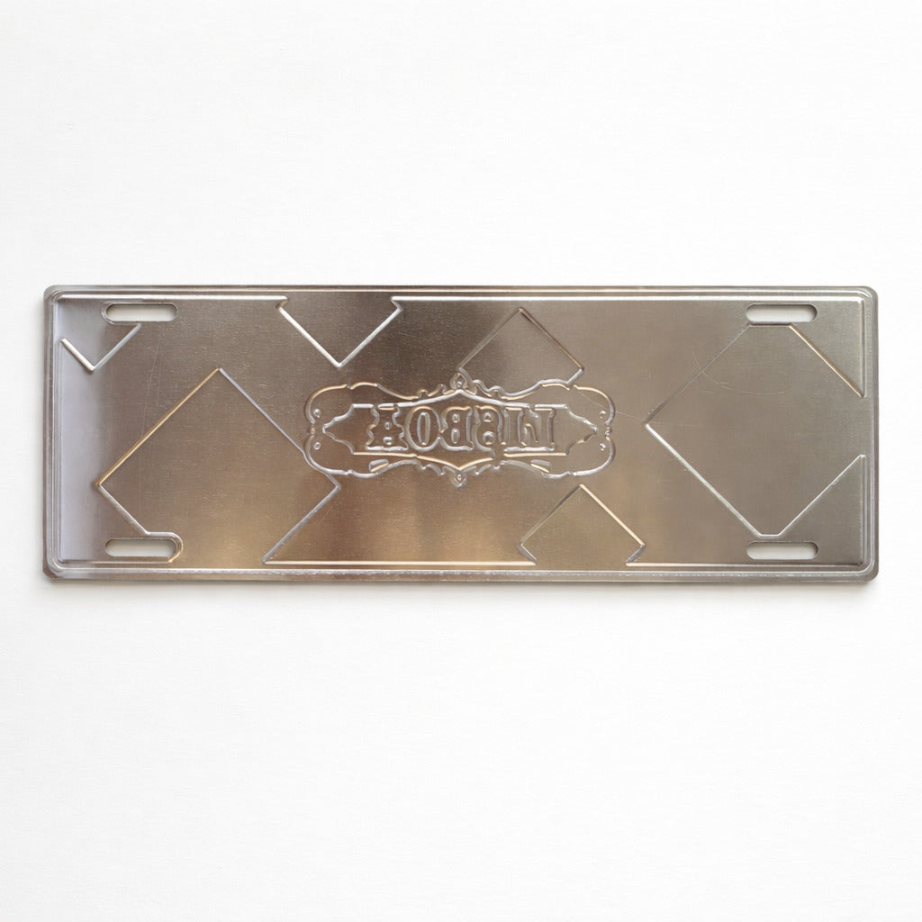 Back side of Lisboa metal souvenir sign showing raw metal surface and mounting slots