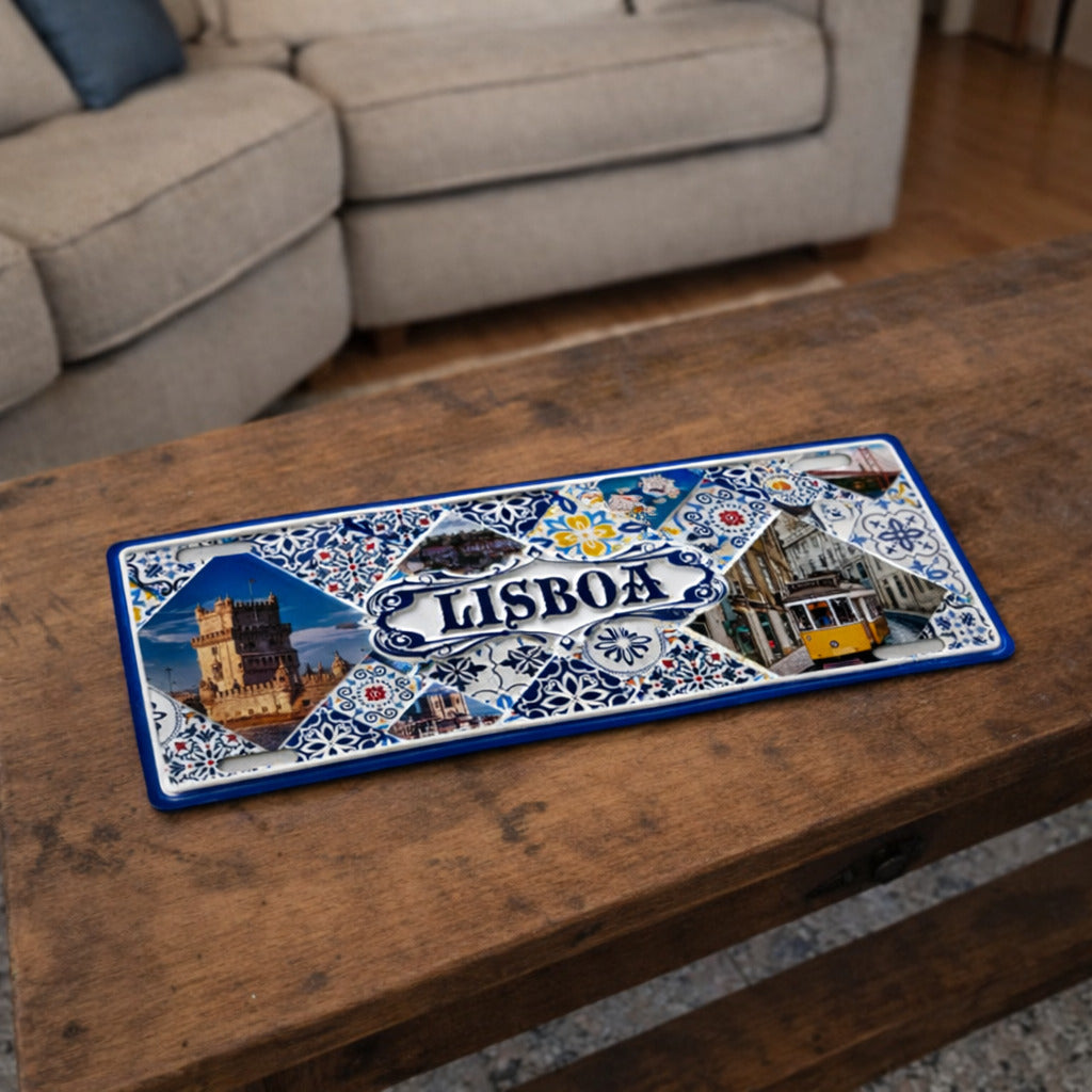 Lisboa metal souvenir sign placed on a wooden table showing Belém Tower, yellow tram and classic Portuguese tile design