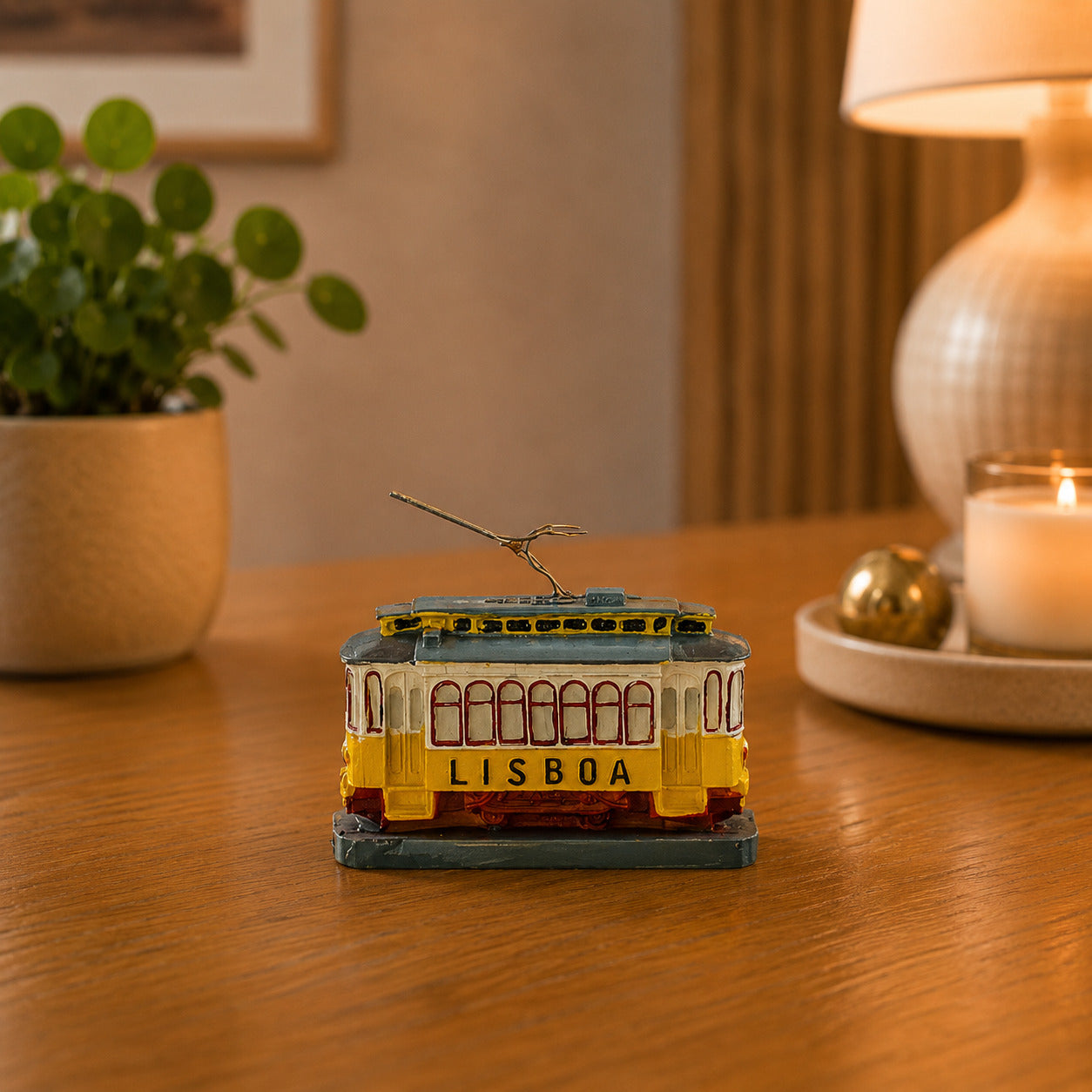 Lisboa yellow tram souvenir replica featuring the famous Lisbon tram design, displayed on a wooden surface with warm ambient lighting.