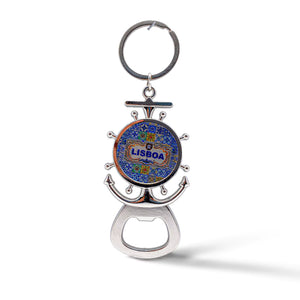 A silver keychain bottle opener, shaped like a ship's wheel and anchor, features a blue and yellow mosaic design with "Lisboa" in the center. This charming souvenir is perfect for any Lisbon enthusiast.