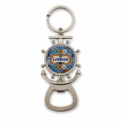 A silver keychain bottle opener, shaped like a ship's wheel and anchor, features a blue and yellow mosaic design with "Lisboa" in the center. This charming souvenir is perfect for any Lisbon enthusiast.