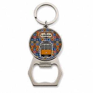 A keychain with a bottle opener attached. The round element shows a colorful illustration of a Lisbon tram with the word "Lisboa" at the top. This charming souvenir features a background pattern reminiscent of traditional Portuguese tiles.