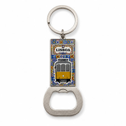 A metal keychain featuring a bottle opener at the bottom and a rectangular enamel tile at the top with a depiction of a Lisbon tram. The word "Lisboa" is written above the tram, surrounded by a decorative blue and yellow border, capturing the charm of Portugal.