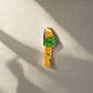 A charming magnet featuring a bikini girl figurine dressed in a green bikini with white polka dots. "LISBOA" appears on the left side of the bottoms, while a small Portuguese flag decorates the right. The figurine stands out against a plain white background.