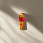 A colorful figurine magnet of a torso wearing a red bikini with white polka dots. "Lisboa" is written on the bikini bottoms, accompanied by a small flag, capturing the spirit of Lisbon. The design stands out against a plain white backdrop.