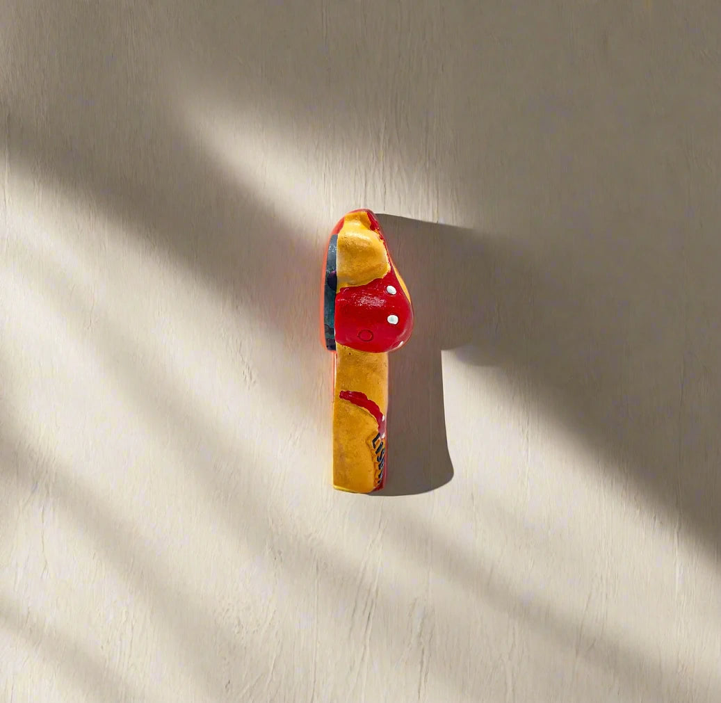 A colorful figurine magnet of a torso wearing a red bikini with white polka dots. "Lisboa" is written on the bikini bottoms, accompanied by a small flag, capturing the spirit of Lisbon. The design stands out against a plain white backdrop.