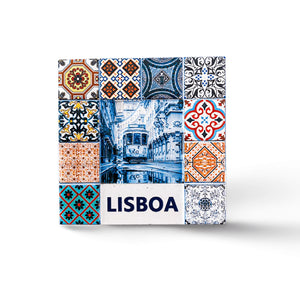 A vibrant collage of traditional Portuguese tiles frames a central image of a tram navigating a narrow street in Lisbon. "LISBOA" is written in bold letters at the bottom. The tiles display intricate patterns in various colors, including blue, red, and orange, making this magnet a perfect souvenir from Portugal.