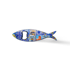Shaped like a sardine, this metal bottle opener is adorned with vibrant, intricate details, highlighting a landmark building and the text "Lisboa." The opener hole is located where the fish’s eye would be, making this a charming memento from Portugal.