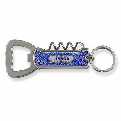 A multi-functional keychain featuring a metal bottle opener and corkscrew. The handle is blue with a textured surface, and the word "LISBOA" is printed on it. The keyring is attached to the top, ready to be connected to a set of keys. Perfect for any adventure from Lisbon to your backyard.