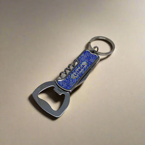 A versatile keychain equipped with a metal bottle opener and corkscrew. It features a blue handle with a textured grip and the word "LIFEGUARD" printed on it. The keyring at the top makes it easy to attach to your keys, making it an ideal accessory for any adventure, whether in Lisbon or your own backyard.