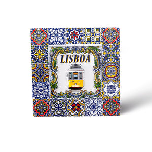 A colorful decorative tile with intricate patterns in blue, yellow, and green surrounds a central image of a yellow tram and the word "LISBOA" above it. This stunning souvenir captures the essence of Portugal, reminiscent of traditional Portuguese azulejos.