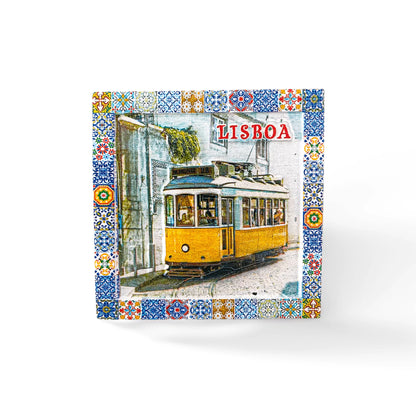 A decorative tile magnet features a classic yellow tram in Lisbon, bordered by a colorful, intricate mosaic pattern. The word "Lisboa" is prominently displayed at the top right, emphasizing the city's name and making it a perfect Portugal souvenir.