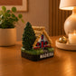 Madeira Santana House souvenir magnet displayed on a wooden table, featuring the traditional thatched-roof cottage that symbolizes the island's cultural heritage.