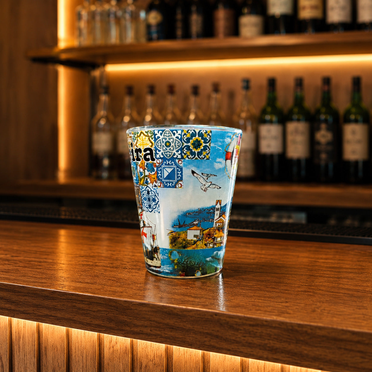 Front view of Madeira souvenir shot glass featuring Portuguese azulejo tiles, traditional caravel ship illustrations, and colorful island artwork