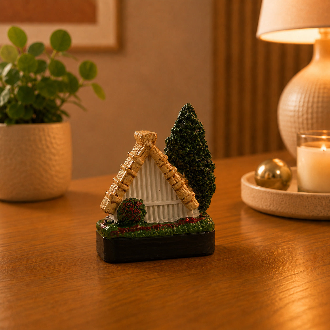 Detailed Madeira souvenir magnet showcasing a traditional Santana cottage with colourful windows, a straw roof, and lush greenery.