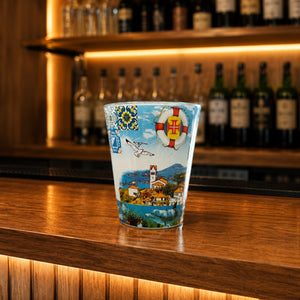 Colorful Madeira souvenir shot glass featuring tropical parrots, traditional houses, ocean wildlife, and Portuguese-inspired decorative patterns