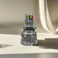 A detailed miniature replica of Lisbon's iconic Belem Tower is displayed, with the word "PORTUGAL" elegantly inscribed in gold at the base. The intricate design of the tower stands out against a clean, white background.