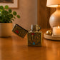 Open metal petrol lighter with Portugal rooster artwork, antique brass finish, and traditional wind-resistant mechanism.