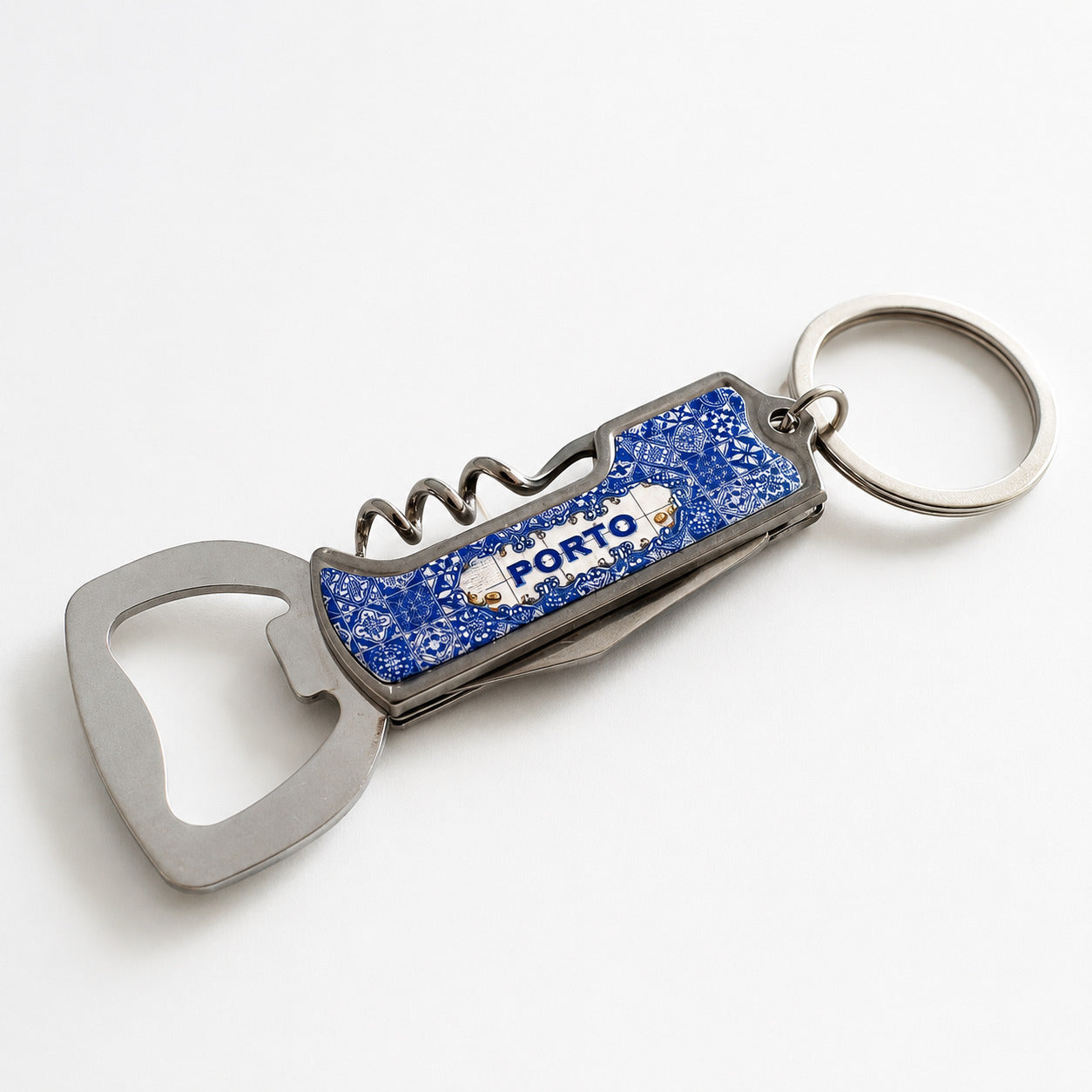 Folded Porto souvenir keychain featuring traditional blue azulejo artwork with integrated bottle opener and corkscrew.