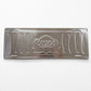 Backside of Porto metal souvenir sign showing engraved sardine shapes and embossed design on a metallic surface