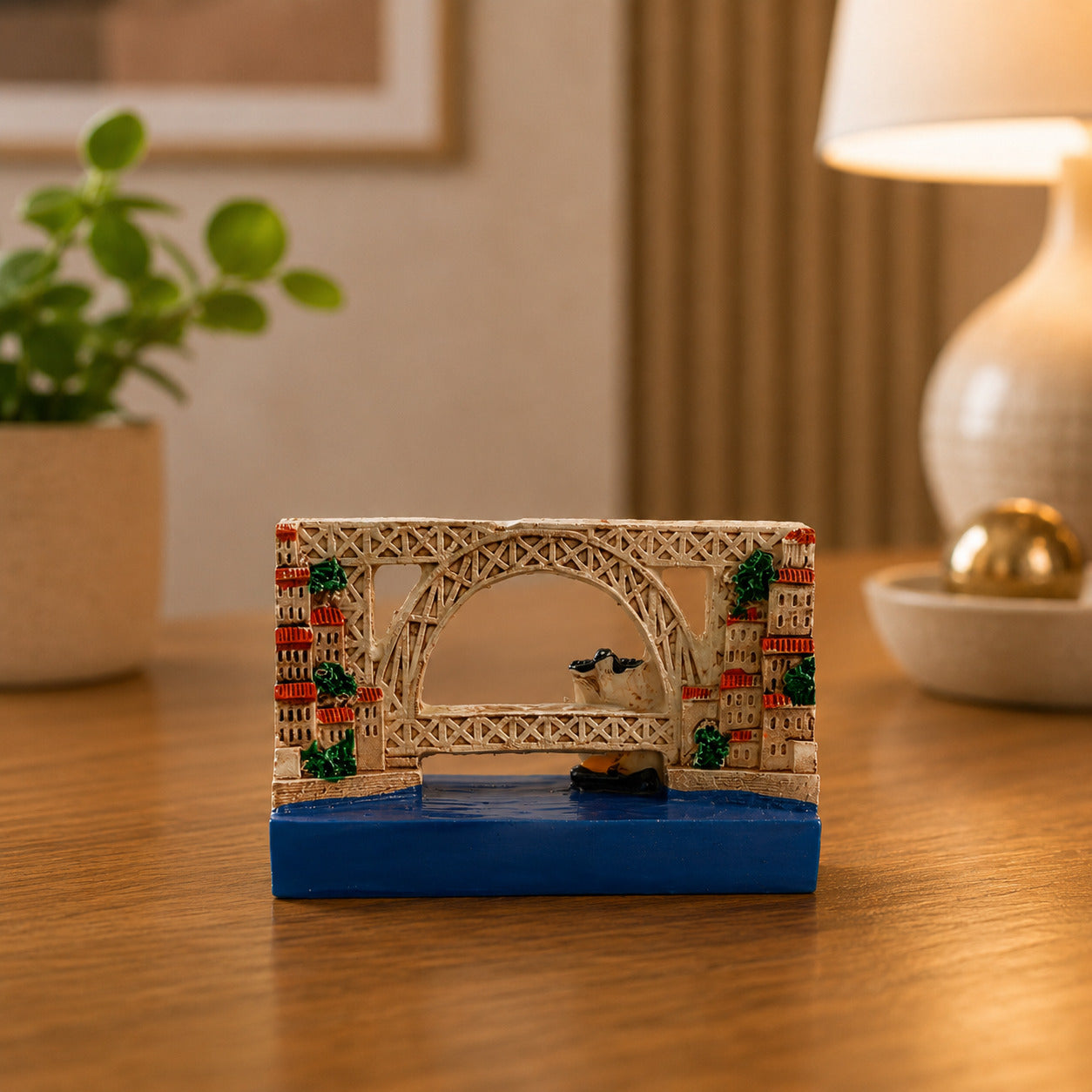 Detailed Porto souvenir magnet showcasing the Dom Luís I Bridge, colourful riverside buildings, and a traditional Rabelo boat sailing on the Douro River.