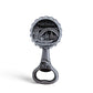 A silver bottle opener souvenir featuring an engraved image of a bridge and cityscape labeled "PORTUGAL" with "PORTO-PORTUGAL" written underneath. The handle also has an engraving of a tram. The background is a plain white.