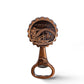 A bronze bottle opener featuring a detailed engraving of the Dom Luís I Bridge in Porto, Portugal. Above the bridge, the word "PORTUGAL" is inscribed. A classic tram is also depicted at the bottom of this souvenir, symbolizing Porto's charm.