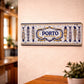 Porto metal souvenir sign mounted on a wall featuring traditional Portuguese azulejos patterns and decorative sardines
