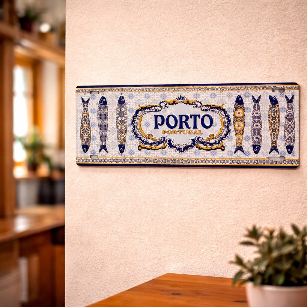 Porto metal souvenir sign mounted on a wall featuring traditional Portuguese azulejos patterns and decorative sardines