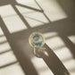 Top view of Portugal azulejo souvenir shot glass with colorful Portuguese tile patterns casting a shadow on a light background.