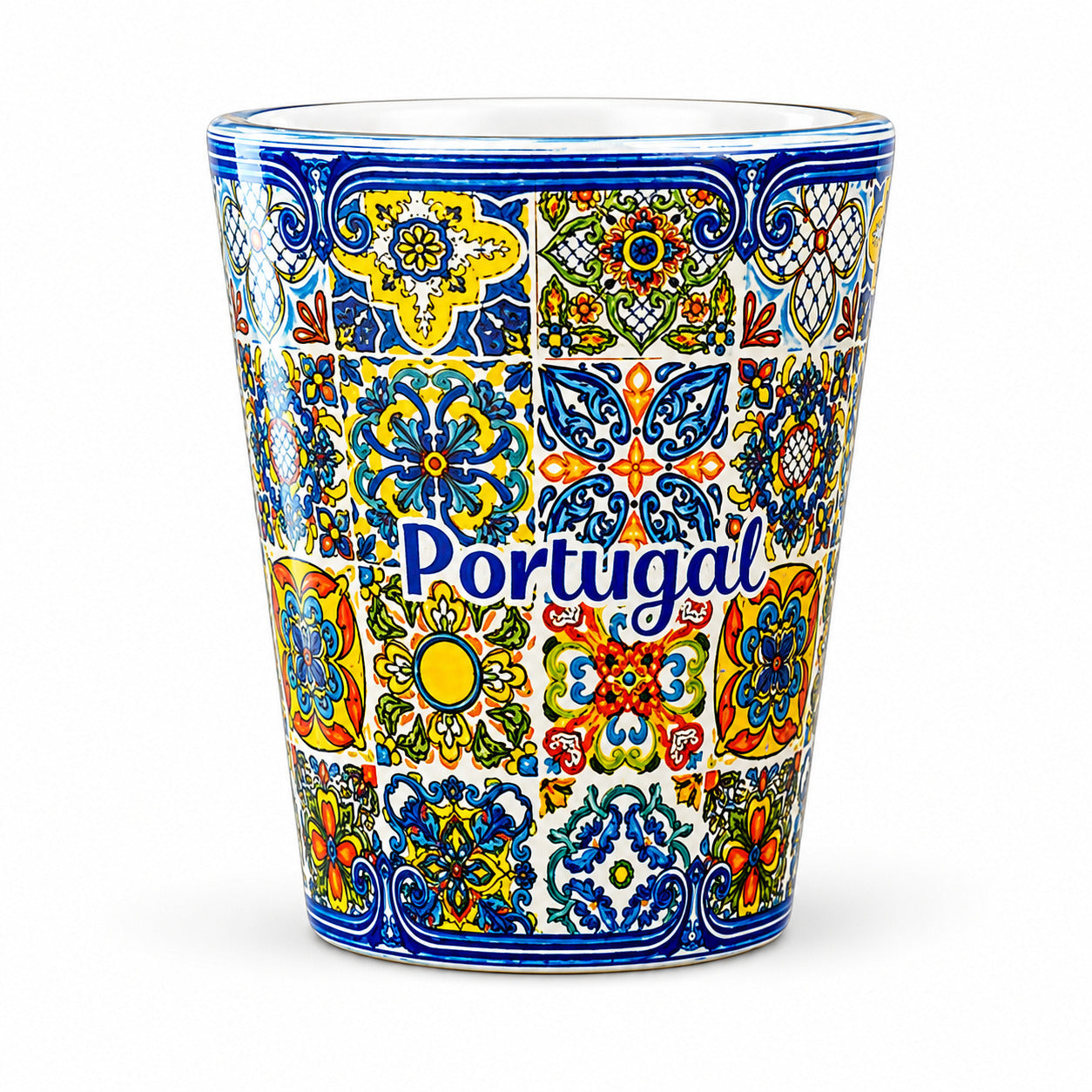 Transparent Portugal shot glass fully decorated with traditional Portuguese azulejo tile patterns isolated on white background.