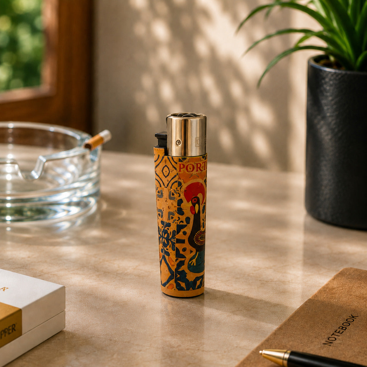 Portugal cork Clipper lighter featuring the traditional Barcelos Rooster and Portuguese azulejo-inspired artwork displayed on a desk in a warm lifestyle setting