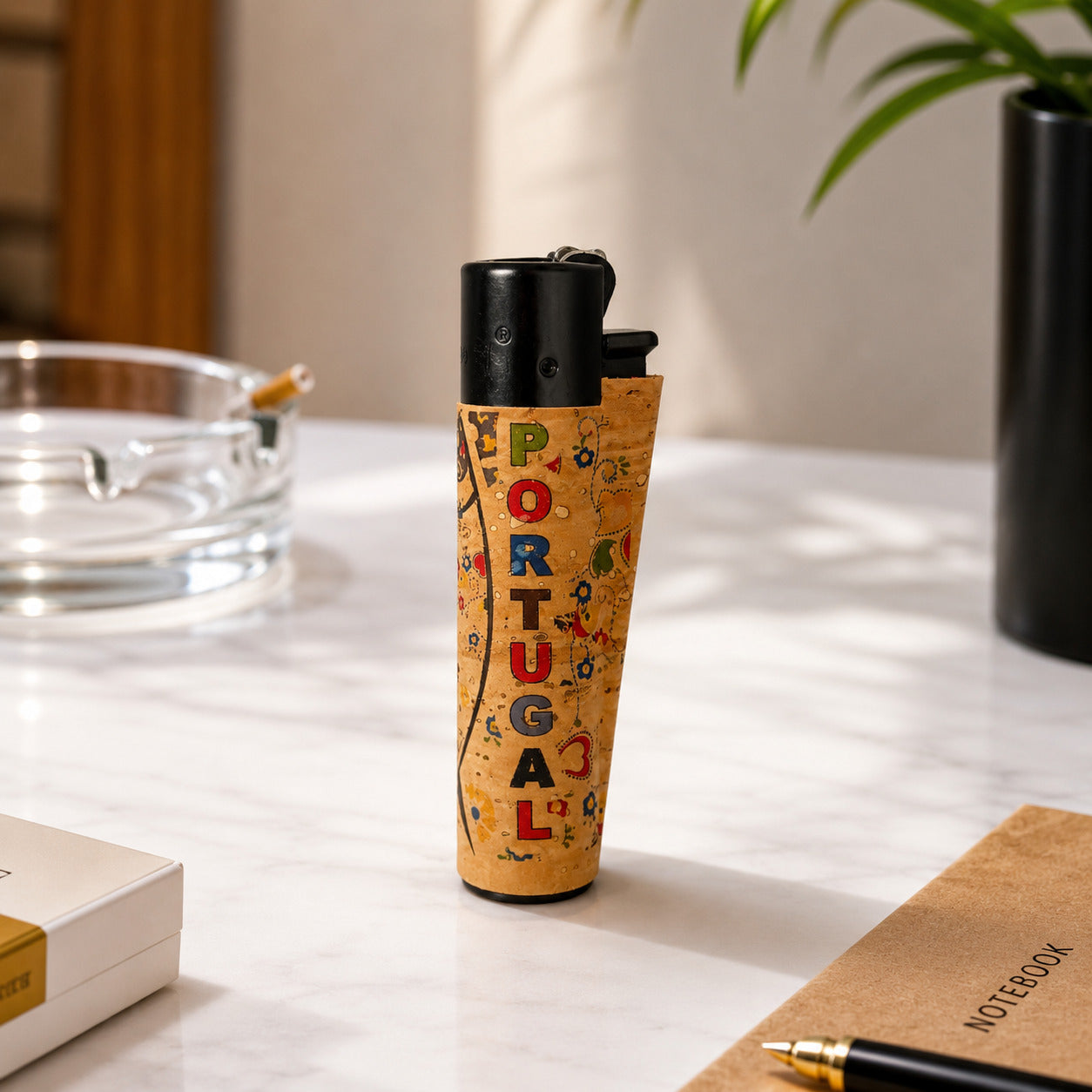 Portugal cork Clipper lighter featuring colourful Portugal lettering, folk-inspired decorative patterns and traditional Portuguese motifs displayed in a lifestyle environment with natural light.