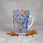 A vibrant ceramic coffee mug with a mosaic tile pattern and the word "PORTUGAL" prominently displayed in the center. The mug showcases intricate blue and yellow designs inspired by traditional Portuguese tiles and includes a small blue ceramic spoon attached to the handle, making it a unique souvenir.