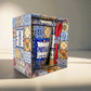 A decorative gift set displaying a colorful Portuguese tile design. This charming souvenir includes a coffee mug labeled "Portugal", a spoon, and a coaster, all enclosed in a matching patterned box. The intricate tile patterns feature blue, yellow, and orange hues.