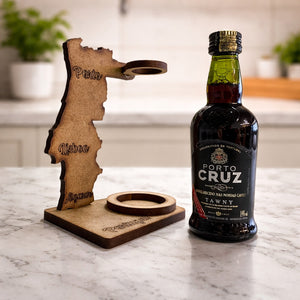 Portugal-shaped wooden souvenir stand with engraved cities Porto, Lisboa and Algarve shown next to the Porto Cruz Tawny Port wine bottle.