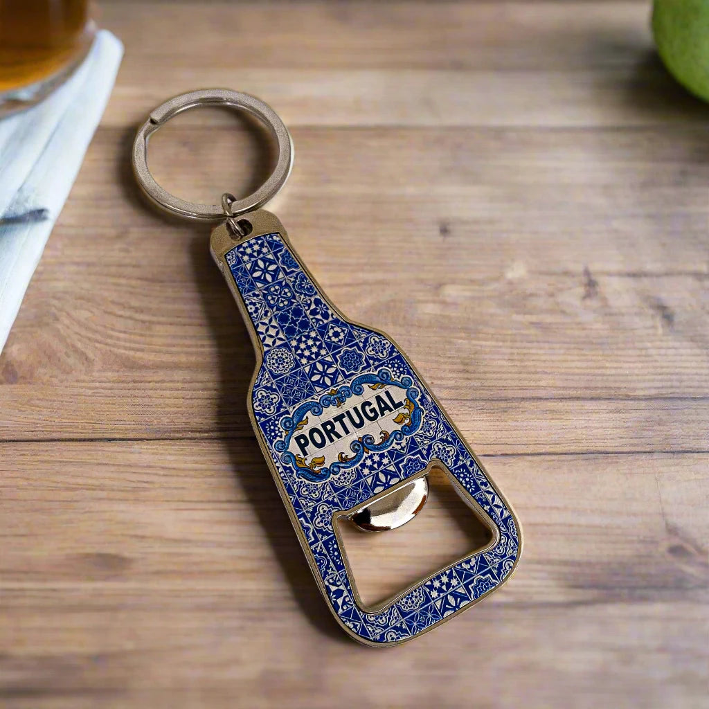 
This keychain, shaped like a bottle with a bottle opener at its base, is a delightful souvenir adorned with intricate blue patterns inspired by traditional Portuguese tiles. The word "Portugal" is elegantly displayed in the center.