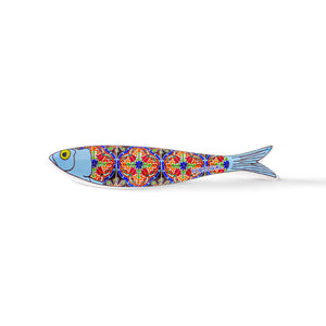 A stylized ceramic fish magnet featuring a blue head, yellow eye, and an intricate, colorful body pattern resembling traditional Portuguese tiles. The vibrant reds, blues, and yellows on its body showcase the word "Portugal" near the tail. This charming souvenir is isolated on a white background.