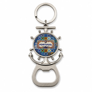 A metal key chain shaped like a ship's wheel and anchor with a colorful design in the center reading "Portugal". At the base, there is a bottle opener and a magnet on the back.