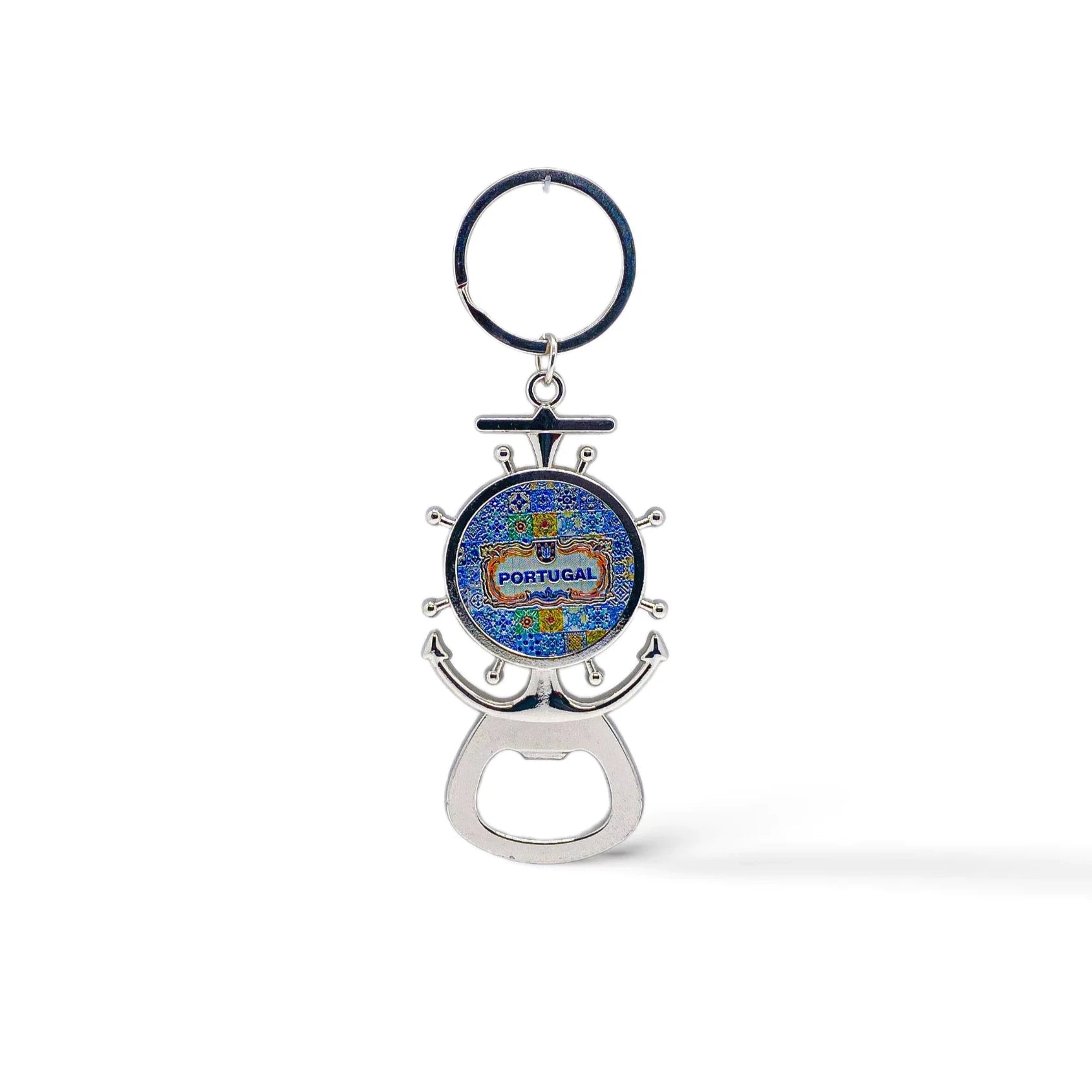 A metal key chain shaped like a ship's wheel and anchor with a colorful design in the center reading "Portugal". At the base, there is a bottle opener and a magnet on the back.