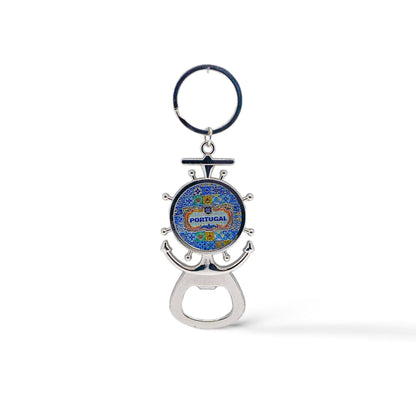 A metal key chain shaped like a ship's wheel and anchor with a colorful design in the center reading "Portugal". At the base, there is a bottle opener and a magnet on the back.