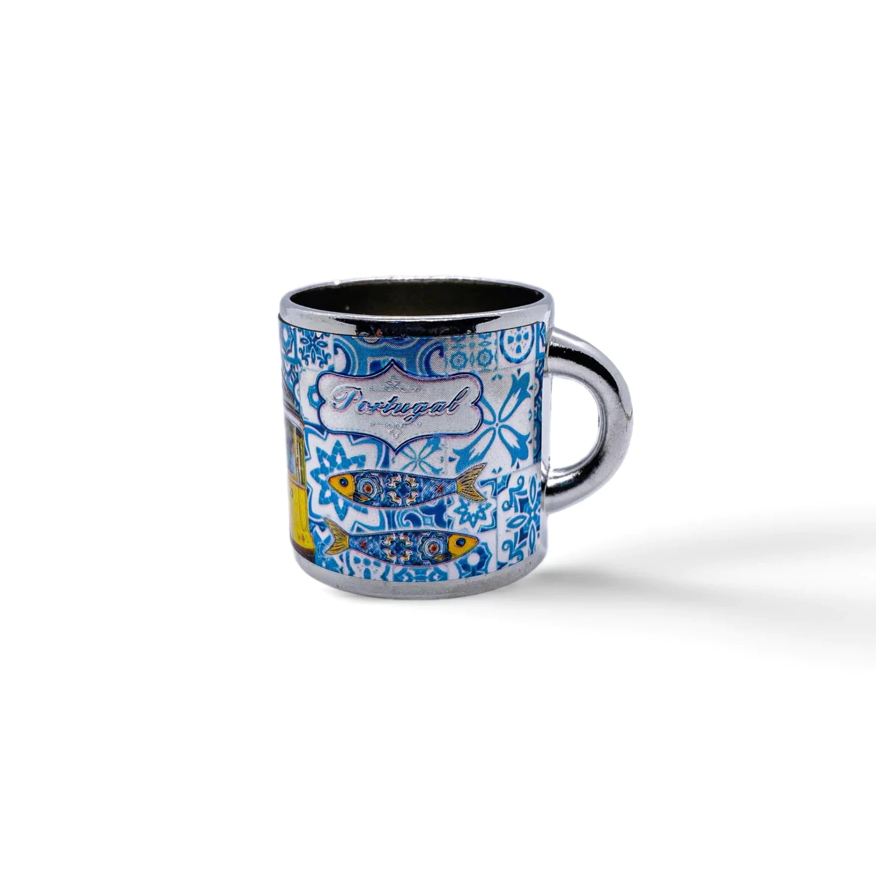 A small blue and white metal shot glass, perfect as a souvenir, is decorated with intricate patterns depicting traditional Portuguese tiles. The word "Portugal" is written centrally among the designs. The cup has a handle on the right side and casts a slight shadow.